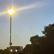 A twilight scene on Blackheath with the planets Venus and Jupiter above silhouetted trees. A Victorian style lamppost shines on the left of the picture