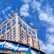 The top of a traditional helter skelter slide reaching into a bright sunny sky