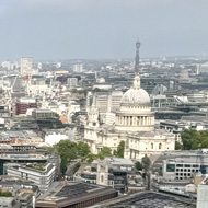 A high level view of London with the thames and St Pauls in the background. Blue sky and clouds above