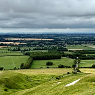 We're standing above the white horse carved into the chalk. There's a flattened hilltop further below, with a small area of chalk visible.