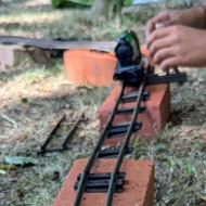 Vintage O-Gague track and train outside on some bricks