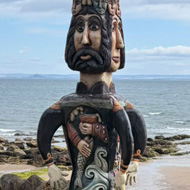 Totem pole of many faces and arms, on the coast of Scotland