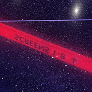 A black reflective floor showing blue and red neon signage in reverse