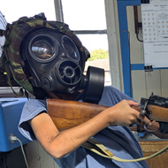 Boy in a gas mask holding a rifle