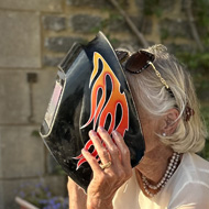 Two older people wearing welding masks