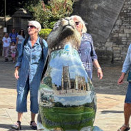 Around the painted five-foot hare outside the parish church in the West Market Place in Cirencester, there's a semi circle of women mid song, whilst passersby stop to watch and listen.