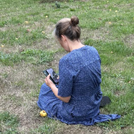 Lady sitting on grass in front of 2026 spelled out in apples